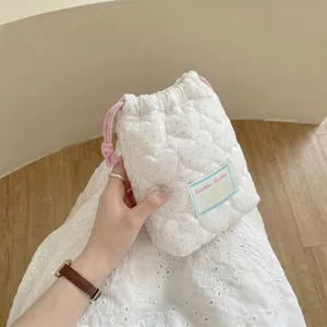 Vista detallada de la bolsa con cordón acolchada de corazón blanco para cosméticos