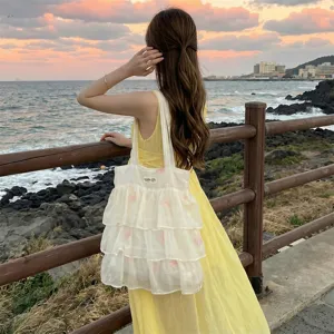 Vista detallada del bolso de organza con volantes y bordado de mariposa rosa