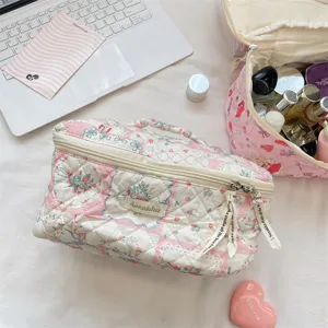 Vista detallada de neceser acolchado con estampado floral y textura suave