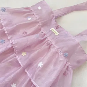 Primer plano de delicadas flores bordadas en un bolso tote de organza lila con capas