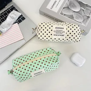 Close-up detail of polka dot canvas storage bags in off-white and green pastel colors