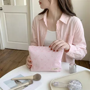 Detail showing embroidered pink bow and heart patterns on this stylish cosmetic pouch