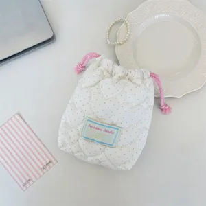 Detalle de bolsa de cordón de corazón acolchada crema con lunares azules y rosa