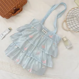 Primer plano bolso de organza azul claro con volantes y bordado de mariposa rosa