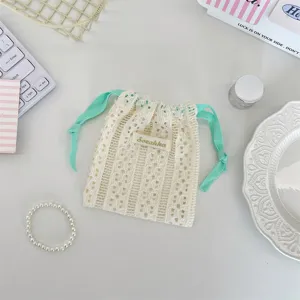Close-up of cream hollow lace drawstring storage bag for cosmetics and accessories