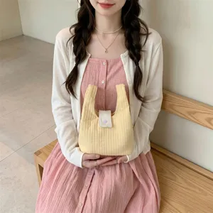 Gele gewatteerde polstas in Japanse stijl vastgehouden door een meisje in roze jurk