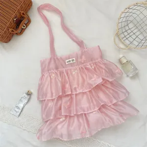 Primer plano de bolso de organza rosa con volantes y bordados de mariposa detallados