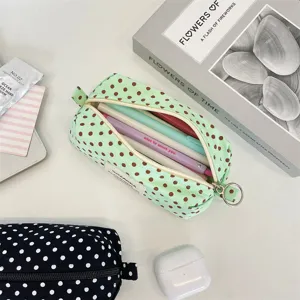 Detail view of a mint green polka dot canvas pencil case showing its interior capacity