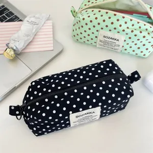 Macro view of black and green polka dot canvas storage pouches with zip closures