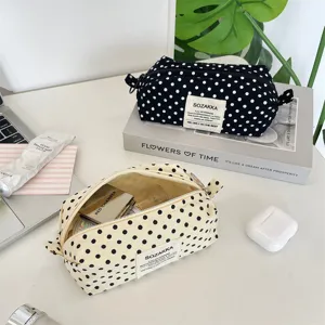 Minimalist off-white canvas polka dot makeup bag shown with aesthetic desk props