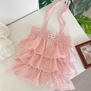 Detalle del bolso tote de organza rosa con volantes y bordados de mariposas.