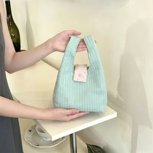 Detail van een mintgroene gewatteerde polstas met een schattige roze hartflap.