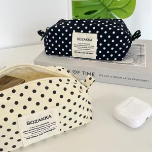 Detailed macro shot of stylish canvas polka dot cosmetic bags in cream and black