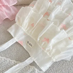 Detalle de bolso de organza con volantes y delicados bordados de mariposas rosas