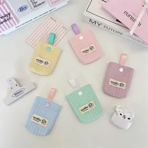 Close-up detail of colorful quilted earphone storage pouches with cute woven labels