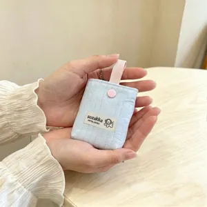 Close-up of light blue quilted mini pouch held in hands for small AirPods storage.