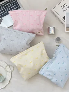 Pastel Japanese style makeup bags featuring bow and heart embroidery in lifestyle setting
