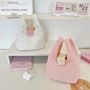 Gedetailleerd beeld van twee gewatteerde mini-handtassen in roze en wit met interieur.