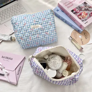 Close-up of blue and purple gingham quilted cosmetic bags for skincare storage