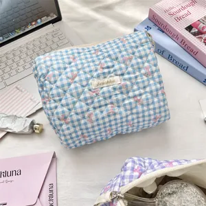 Detailed view of a blue quilted gingham toiletry bag with cute pink bow patterns