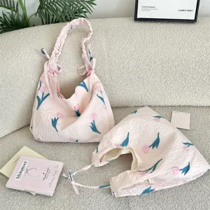 Vue détaillée de sacs fourre-tout plissés tulipe rose sur un canapé beige texturé