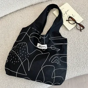Detailansicht der abstrakten weißen Linienkunst auf einer schwarzen Canvas-Tasche