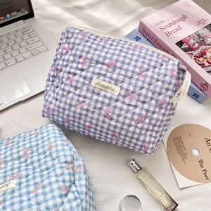 Detail of quilted gingham cosmetic bags in purple and blue checkered patterns.