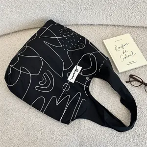 Detailansicht des abstrakten weißen Linienmusters auf einer robusten schwarzen Segeltuchtasche