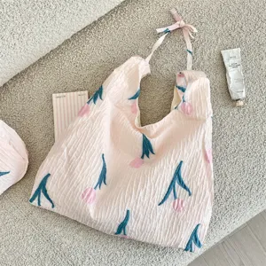 Détail du sac cabas rose clair froissé avec motifs de tulipes et bretelles à nouer