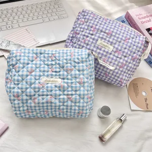 Detail view of blue and purple quilted gingham toiletry bags with ribbon accents