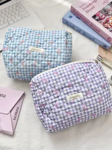Pastel blue and purple gingham quilted cosmetic bags with delicate pink ribbon patterns