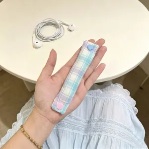 Dettaglio dell'organizzatore di cavi a quadri macaron con bottone a forma di cuore
