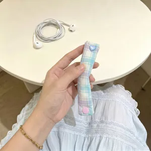 Dettaglio dell'organizzatore cavi a quadri macaron con bottone a pressione a cuore blu
