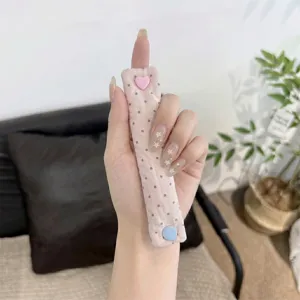 Mano che tiene un simpatico organizer per cavi in tessuto rosa a pois con bottone a cuore