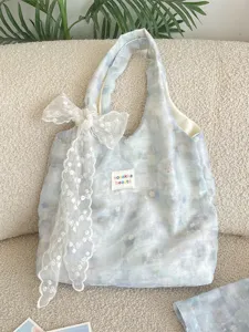 Ice blue gradient floral tote bag with a decorative white lace bow and a patch detail.