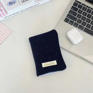 Vista dettagliata del porta passaporto in peluche blu navy con bordi a quadretti blu