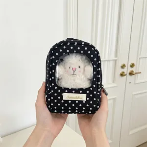 Handheld polka dot doll storage bag featuring a transparent window for plush display