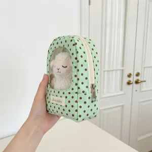 Detailed view of the mint green polka dot plush doll storage pouch with a clear window