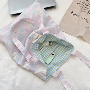 Interior detail of pink and blue plaid canvas tote bag showing large capacity for students