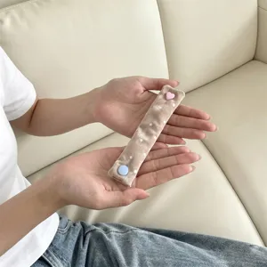 Dettaglio di un ferma cavo in velluto a pois con un simpatico bottone a pressione a cuore