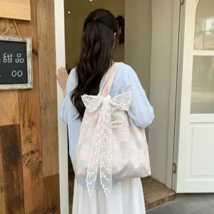 Back view of a feminine pink and blue checkered tote bag with a large white decorative lace bow