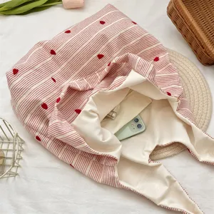 Close-up showing the spacious interior of a pink striped heart embroidered tote bag