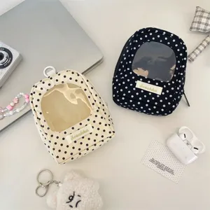 Detail of polka dot doll display pouches with transparent windows in navy and cream color.