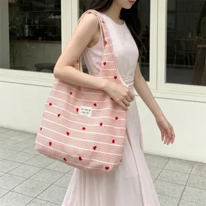 Asian model carrying a stylish pink and white striped tote bag with heart embroidery