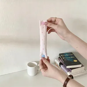 Dettaglio macro di un organizer per cavi rosa con stelle e bottone a scatto a cuore
