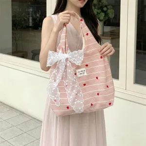 Close-up detail of pink striped heart embroidery tote bag with elegant white lace bow