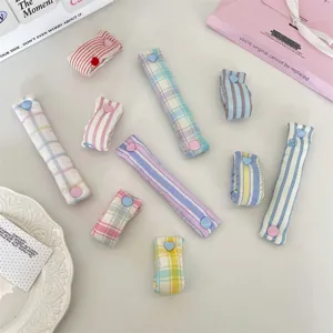 Dettaglio macro di organizer per cavi a quadri macaron con bottoni a pressione a cuore