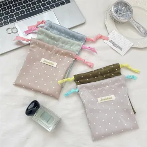 Macro view of macaron polka dot satin drawstring bags with contrast ties