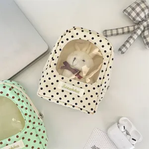 Detail of cream polka dot doll storage bag with transparent display window for plushies.