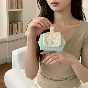 Close-up detail of a floral quilted mini pouch for lipstick and earphones storage